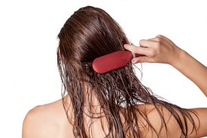 濡れた髪をブラッシングする女性
